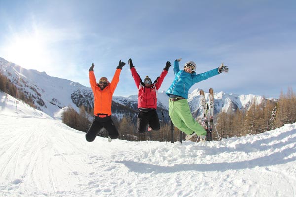 Saut des skieurs heureux en séjour à la montagne